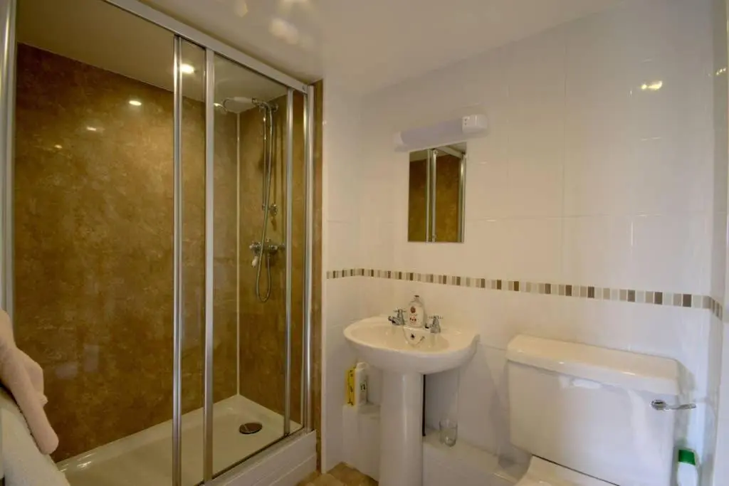 a bathroom with a sink and a shower and a toilet at Easter Corrie Cottages in Ballindalloch