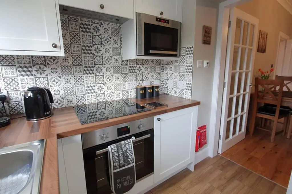 a kitchen with a sink and a stove top oven at Smart & Stylish Holiday Apartment in the city centre in Inverness