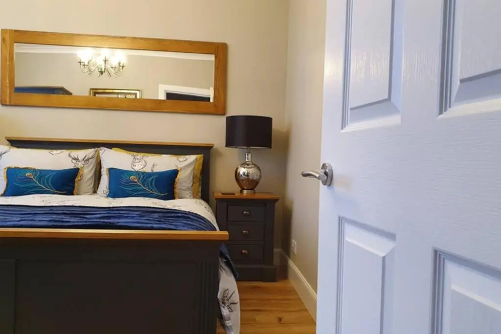 a bedroom with a bed with a mirror on the wall at Smart & Stylish Holiday Apartment in the city centre in Inverness