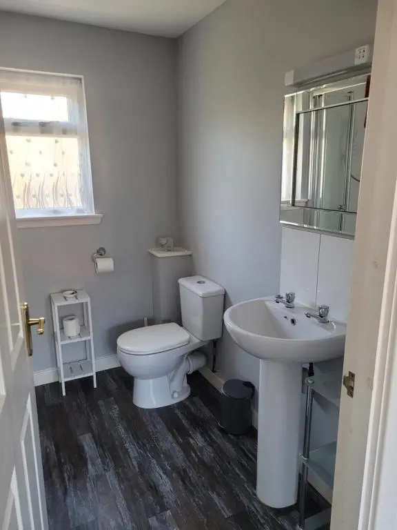 a white bathroom with a toilet and a sink at Arisaig Flat in Inverness