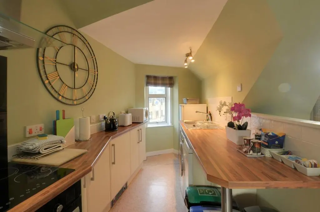 a kitchen with a large clock on the wall at King Street Apartment in Inverness