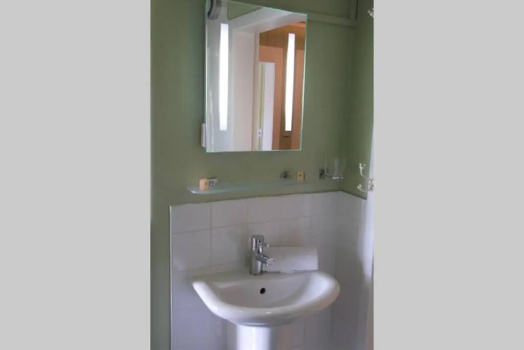 a bathroom with a sink and a mirror at King Street Apartment in Inverness