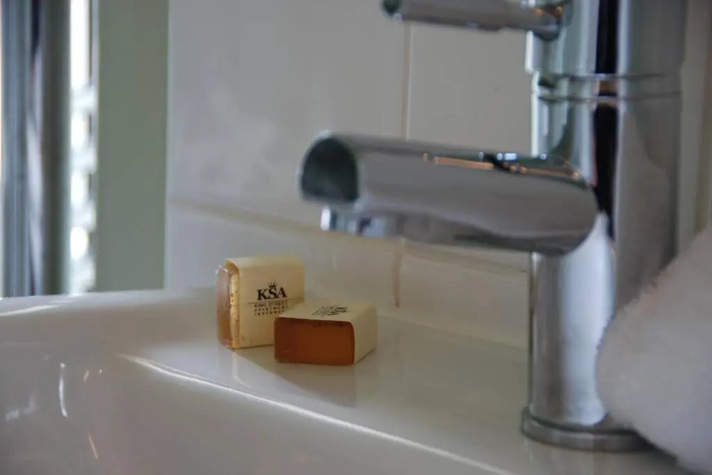 a bathroom sink with a faucet and two complimentary soap at King Street Apartment in Inverness