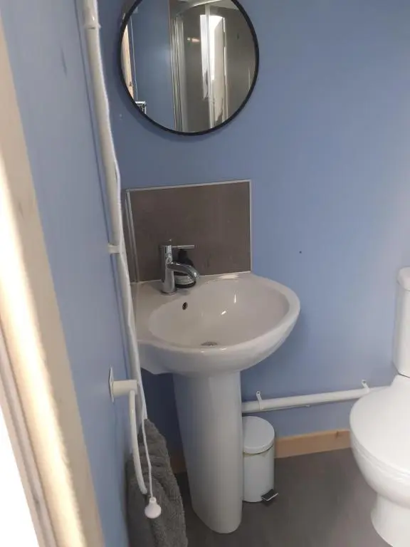 a bathroom with a sink and a mirror at Croft of Clune Shepherds Hut in Newtonmore