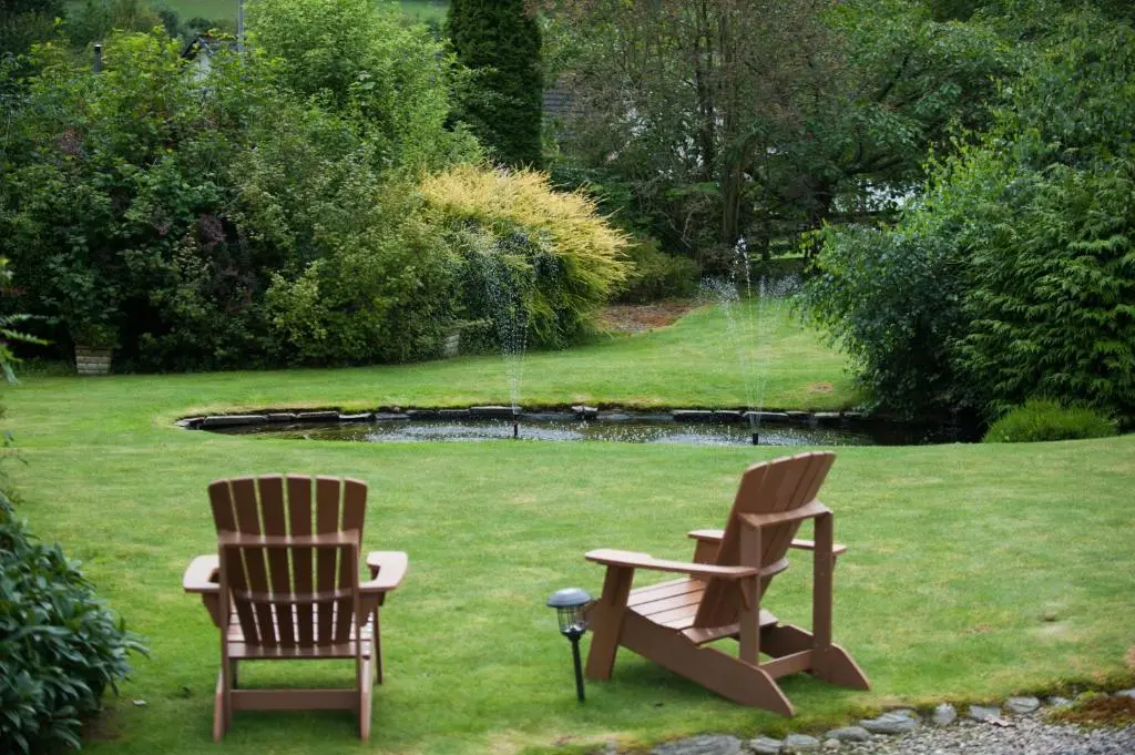 two chairs and a table in the grass at Kilmore Farmhouse in Drumnadrochit