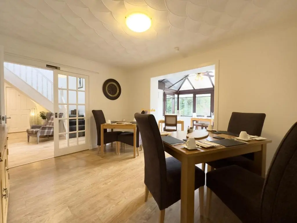 a dining room with a table and chairs and a room at Kilmore Farmhouse in Drumnadrochit