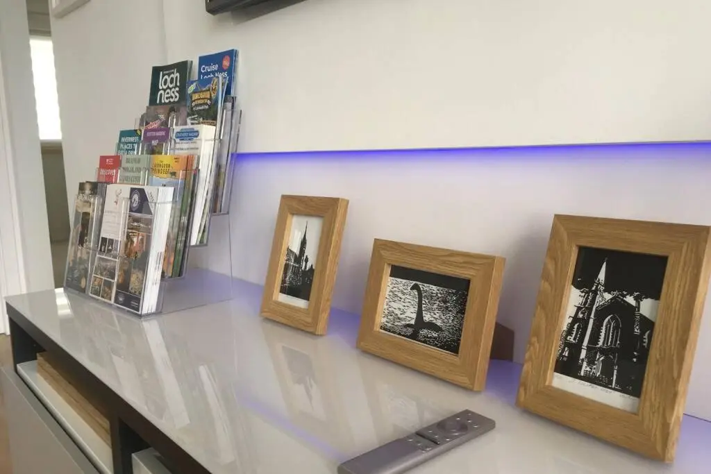 four framed photographs sitting on a counter in a room at Blarmore Apartment Inverness in Inverness