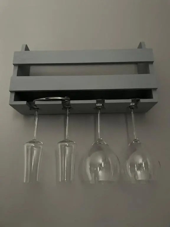 a shelf with wine glasses hanging on a wall at The Chalet in Inverness