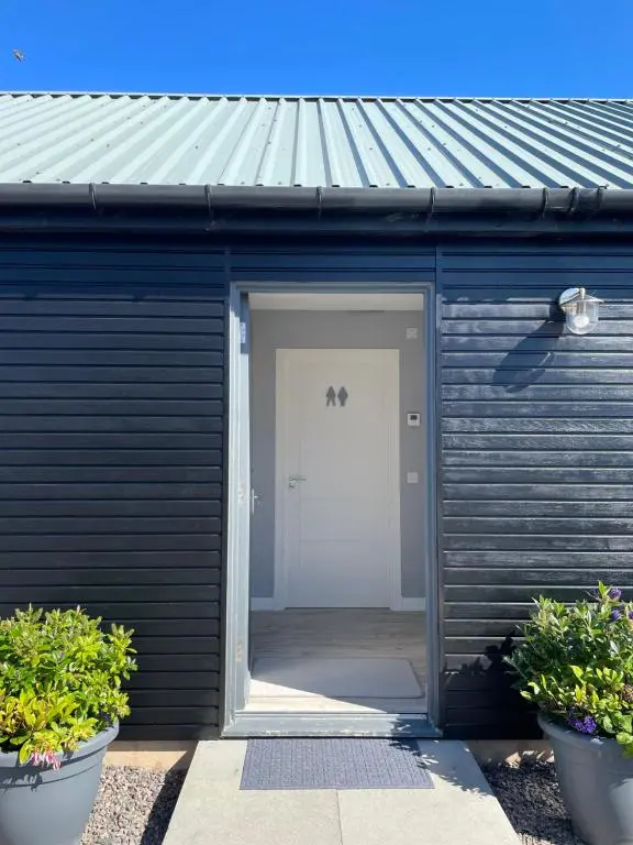 a black garage with a door and a white door at The Chalet in Inverness