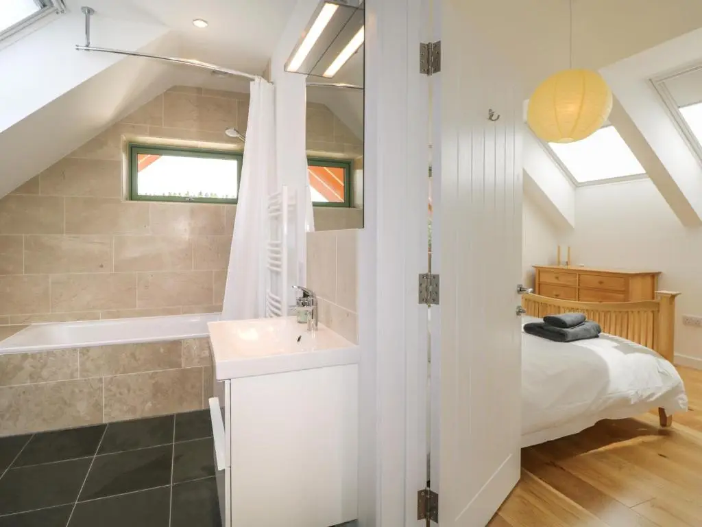 a bathroom with a sink and a bath tub next to a bed at Na Clamhanan in Forres