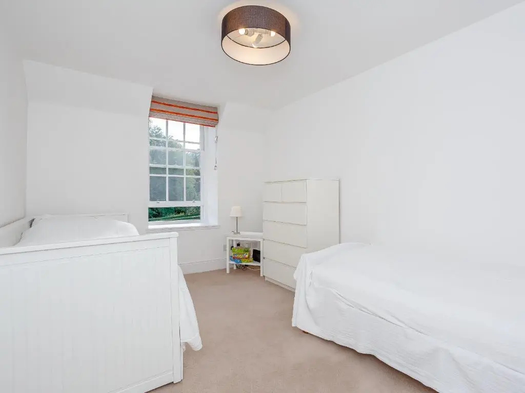 a white bedroom with a bed and a window at Skene House Court in Dunecht