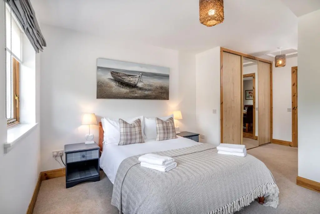 a bedroom with a bed and a boat on the wall at Dormie Cottage, lovely bright and spacious bungalow with wood fire in Ballater