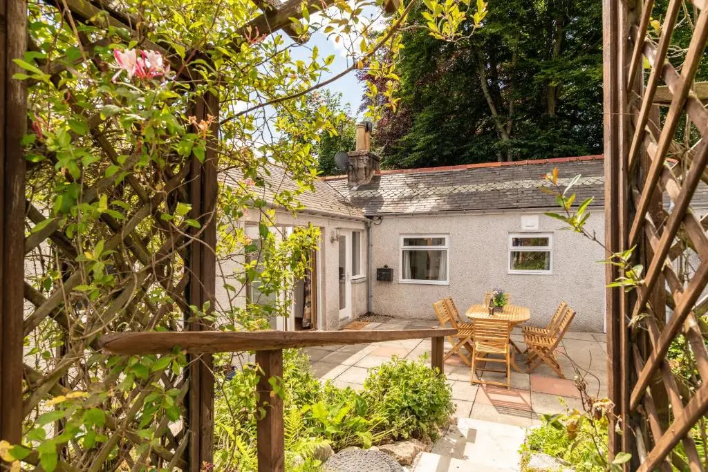 a view of a patio with a table and chairs at Dormie Cottage, lovely bright and spacious bungalow with wood fire in Ballater