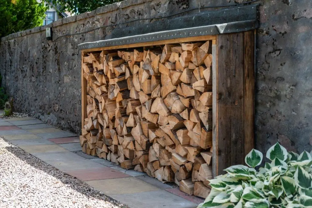 a pile of fire wood in a wooden box at Dormie Cottage, lovely bright and spacious bungalow with wood fire in Ballater