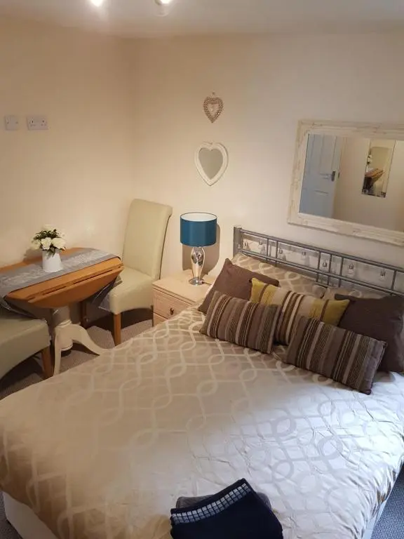 a bedroom with a bed and a table and a desk at The little garden hoose in Inverness