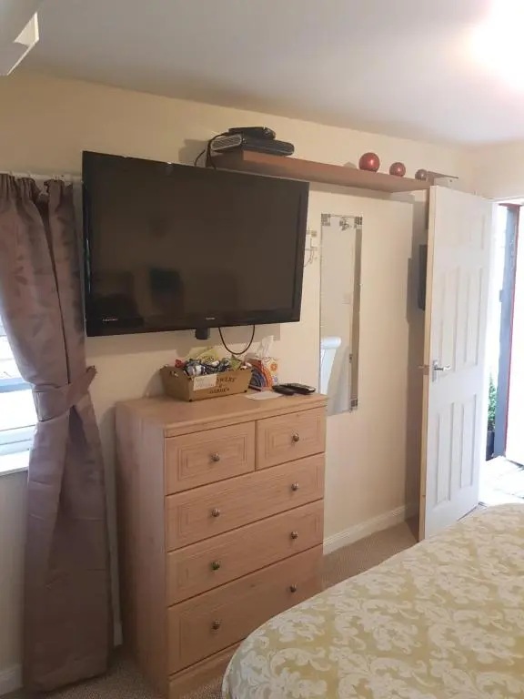 a bedroom with a television on top of a dresser at The little garden hoose in Inverness