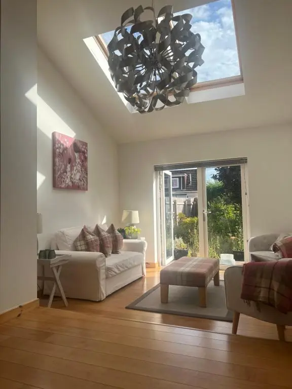 a living room with a couch and a chandelier at Shamerbrea The Foodie B&B in Inverness