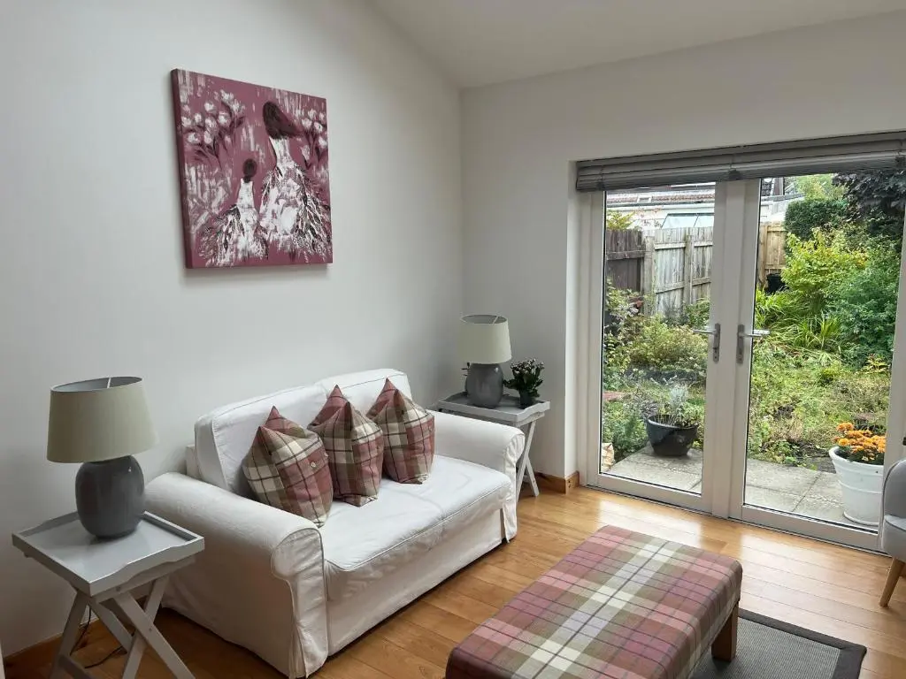 a living room with a white couch and a window at Shamerbrea The Foodie B&B in Inverness