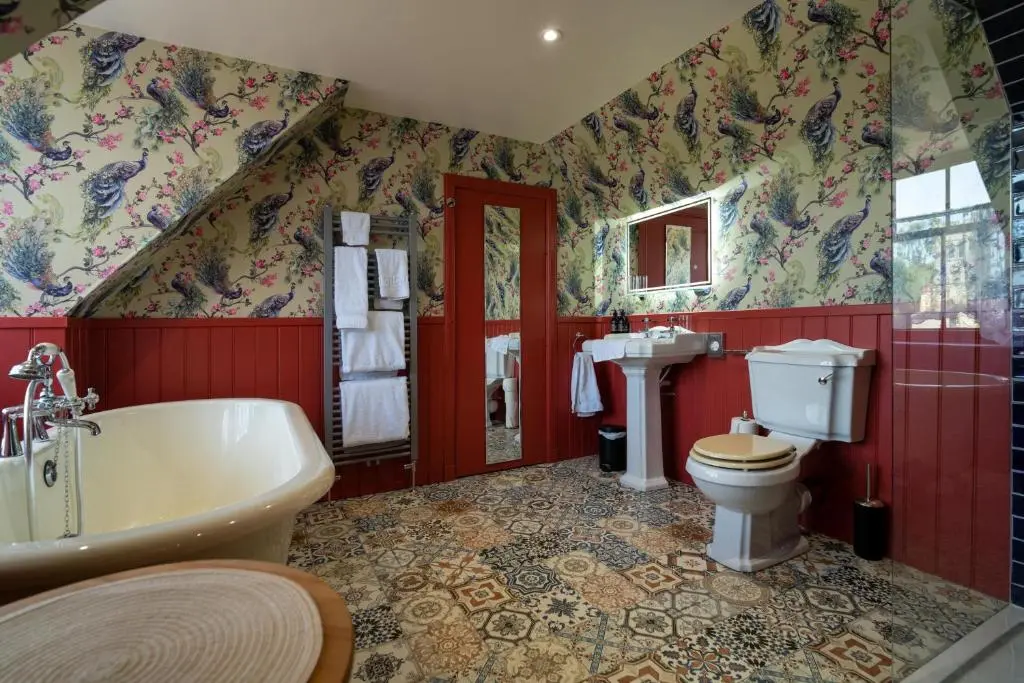 a bathroom with a tub and a toilet and a sink at The Mash Tun in Aberlour