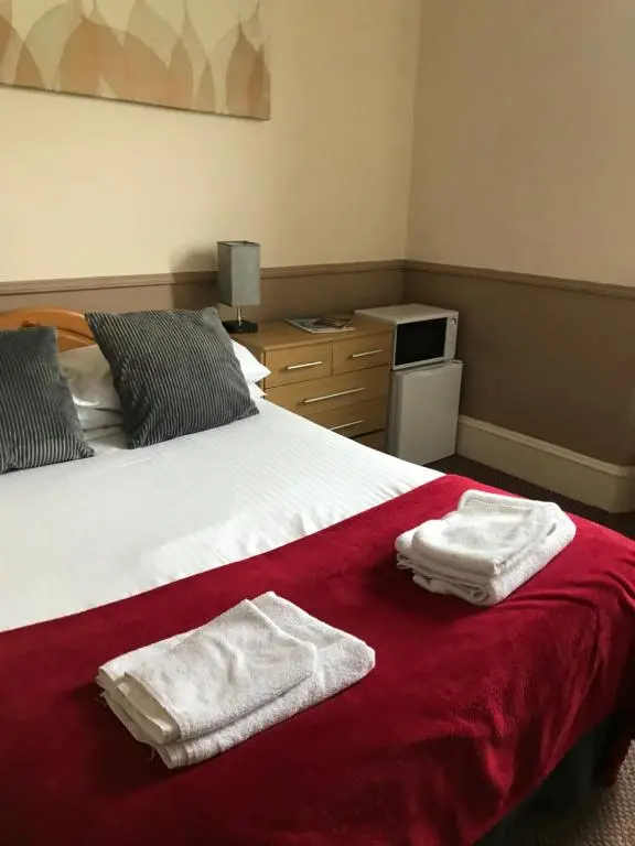 a bedroom with a bed with towels on it at The Banks Of Ury in Inverurie