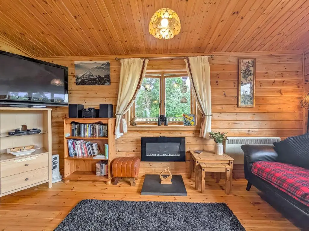 a living room with a couch and a tv at Red Kite Cottage in Tore