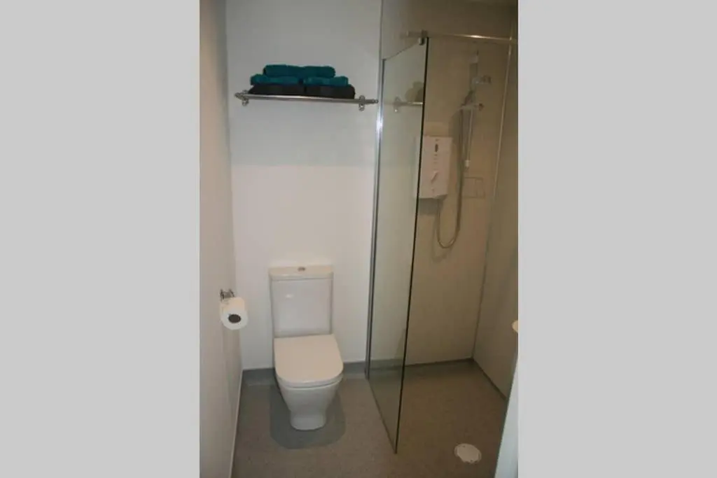 a bathroom with a toilet and a glass shower at The Snug at the Ski Lodge, Aviemore in Aviemore