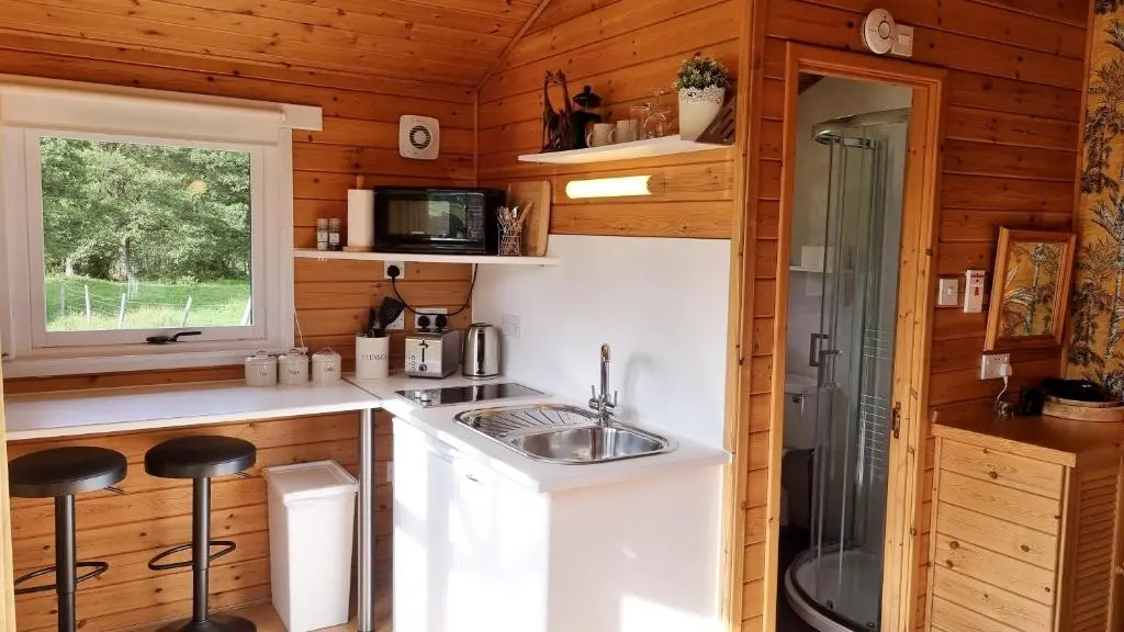 a kitchen with a sink in a tiny house at Cabins at Old Pier House in Fort Augustus