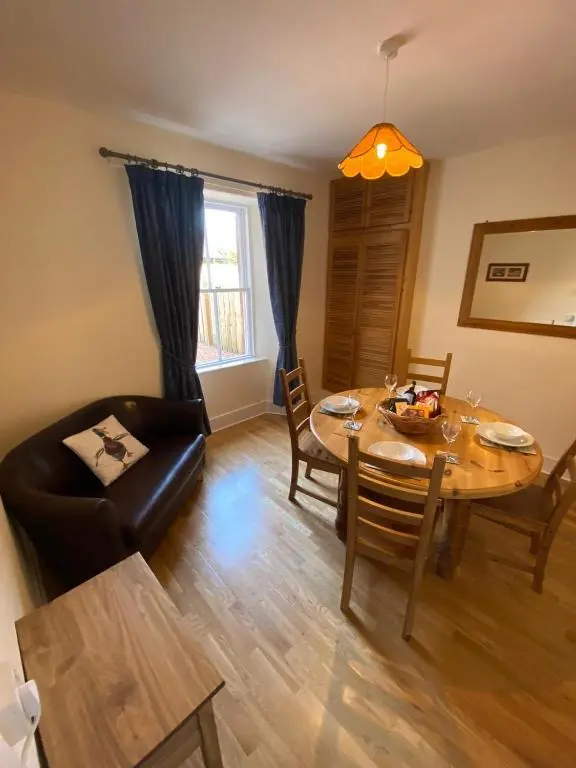 a living room with a table and chairs and a dining room at No. 20 in Inverness