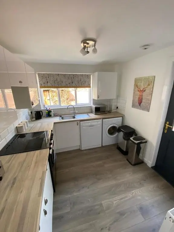 a kitchen with white cabinets and a sink at No. 20 in Inverness