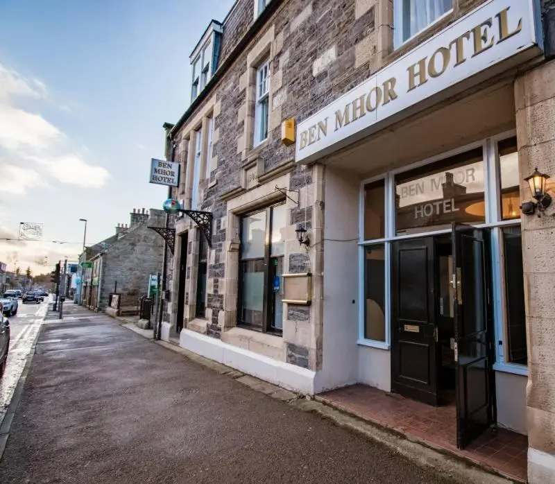 a building with a sign for a hotel on a street at The Ben Mhor Hotel, Bar & Restaurant in Grantown on Spey