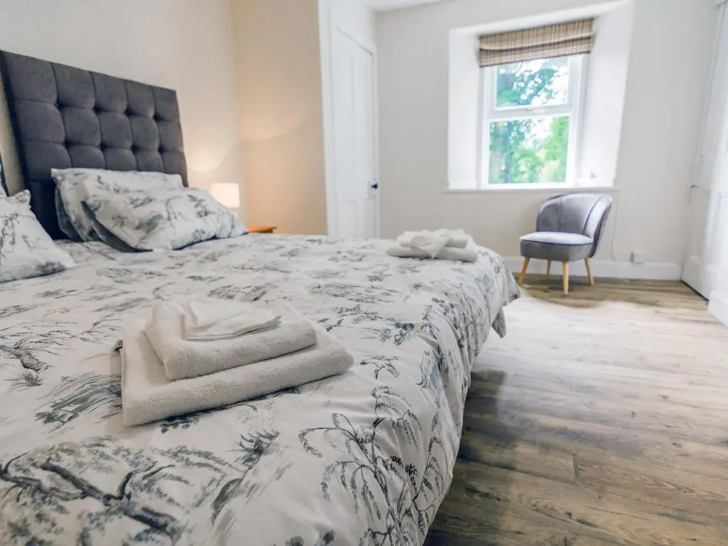a bedroom with a bed with a blue and white comforter at Keepers Cottage - Uk30246 in Cray