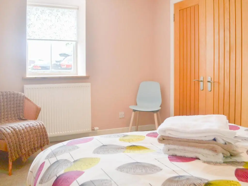 a room with a bed with a glass table at Mansefield Cottage in Boyndie