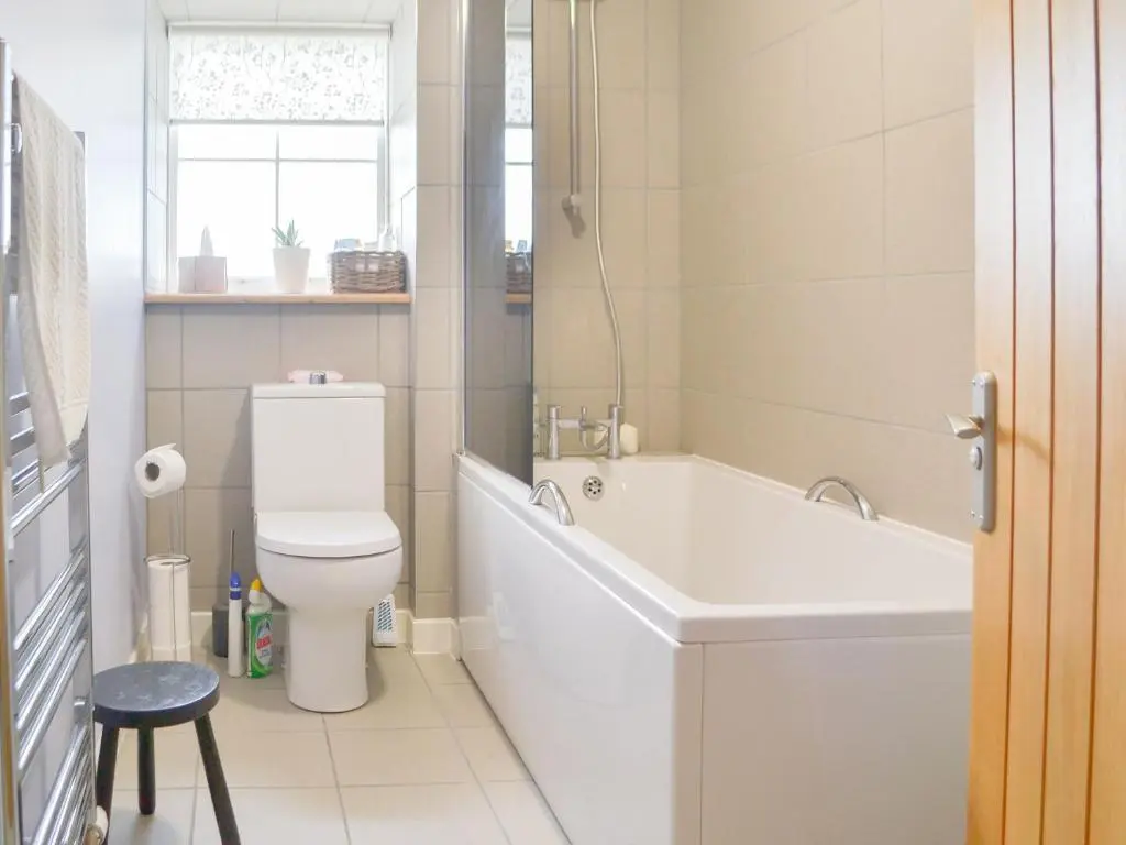 a bathroom with a bath tub and a toilet at Mansefield Cottage in Boyndie