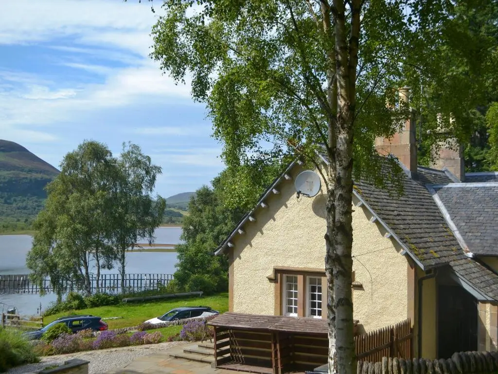 a building with a view of a lake at Sluice Keeper's Cottage in Skelbo