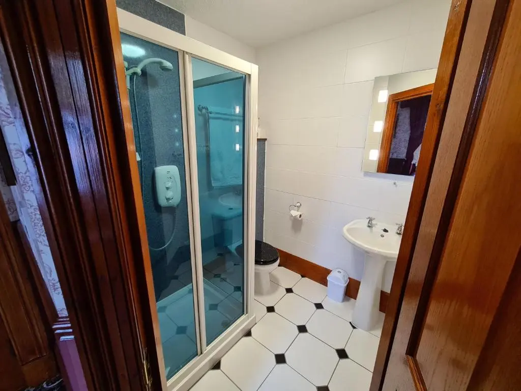 a bathroom with a glass shower and a sink at Bluebell House in Inverness