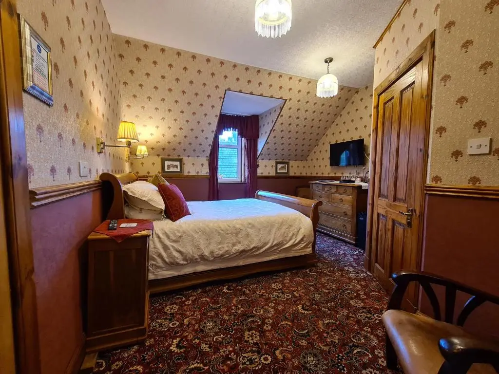 a bedroom with a bed and a television in it at Bluebell House in Inverness