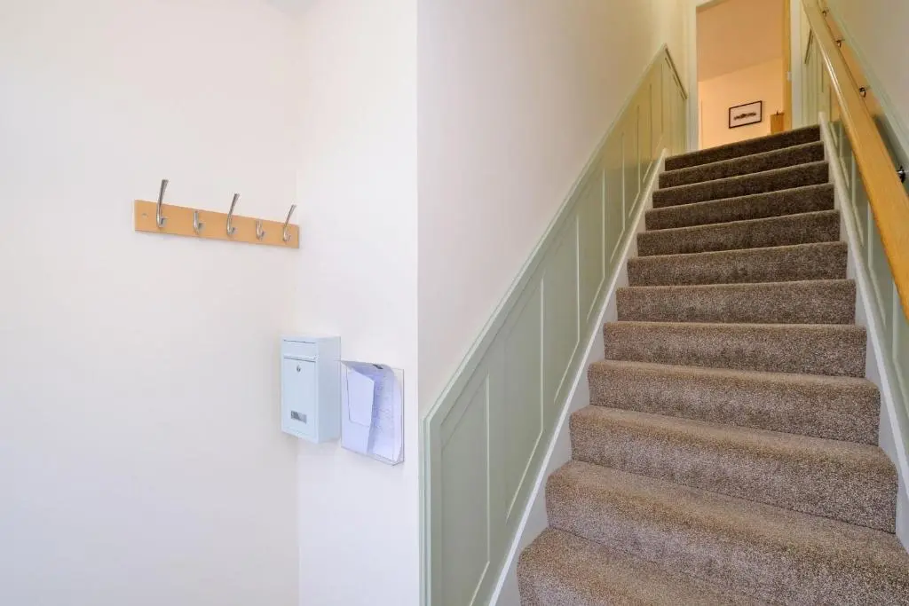 a staircase in a house with a stairwell at Caledonia Newhills Apartment in Aberdeen