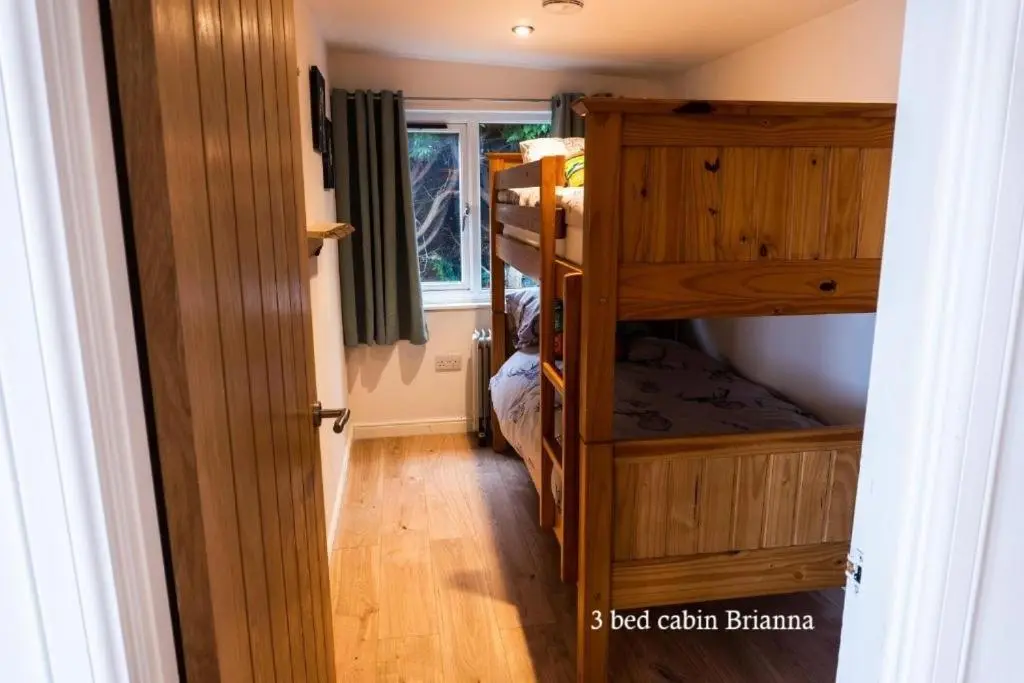 a room with two bunk beds and a hallway at Culbokie Lodges in Culbokie