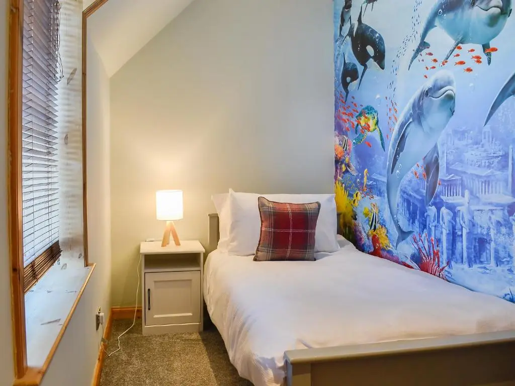 a bedroom with a bed with a painting on the wall at East Lewiston in Drumnadrochit