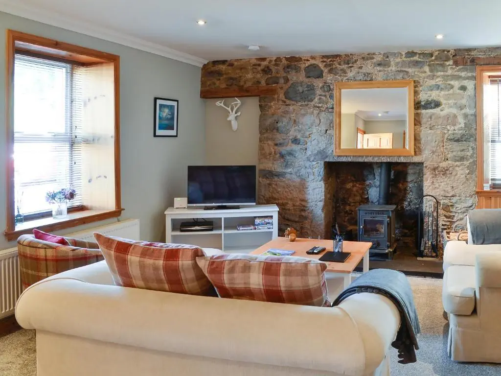 a living room with a couch and a tv at East Lewiston in Drumnadrochit