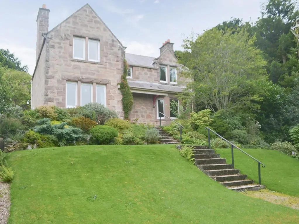 a large stone house with a grass yard at Braehead in Nairn