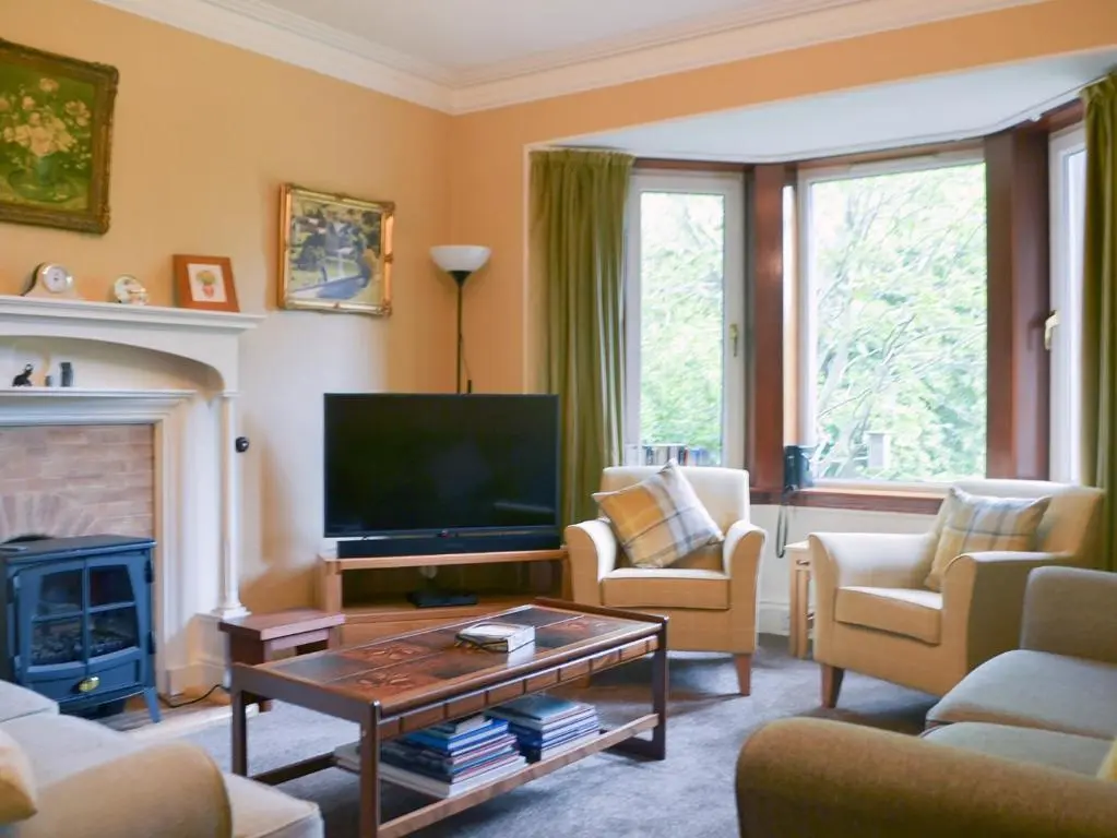 a living room with a television and a fireplace at Braehead in Nairn