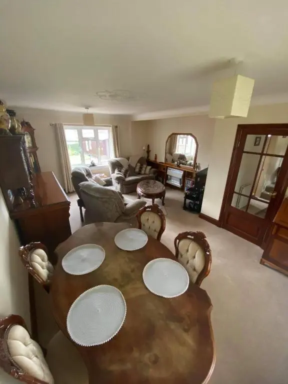 a living room with a wooden table and chairs at Dallaire House in Banchory
