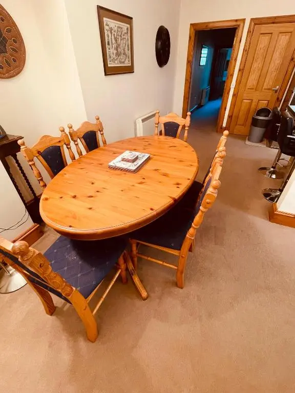 a wooden table and chairs in a room at Dalmore in Nairn