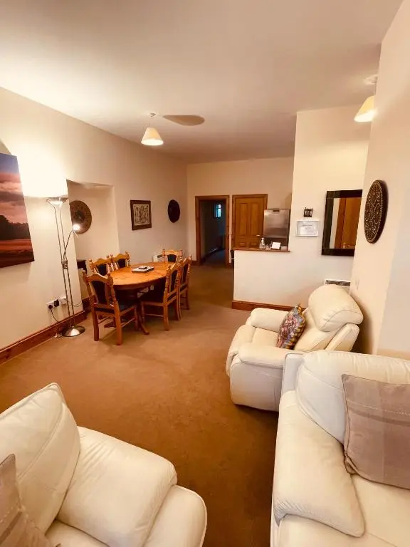 a living room with white couches and a table at Dalmore in Nairn