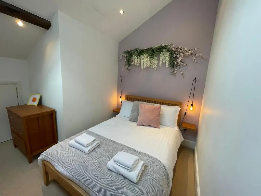 a bedroom with a bed with two towels on it at The Bell Tower in Inverness