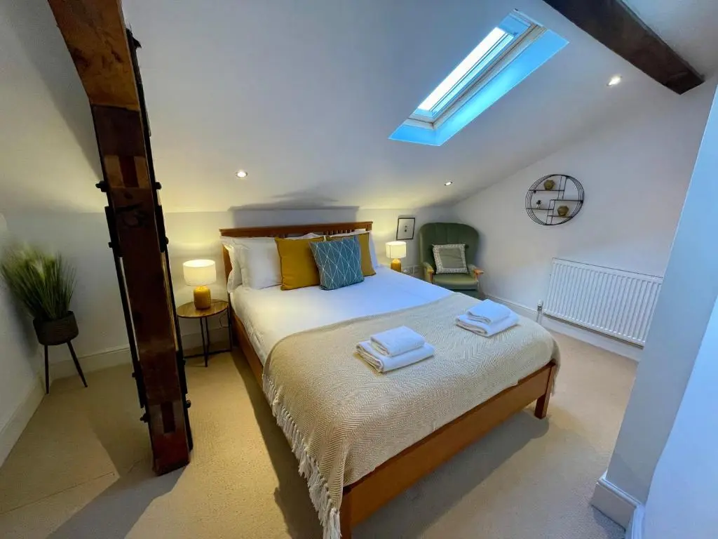 a bedroom with a bed with two towels on it at The Bell Tower in Inverness
