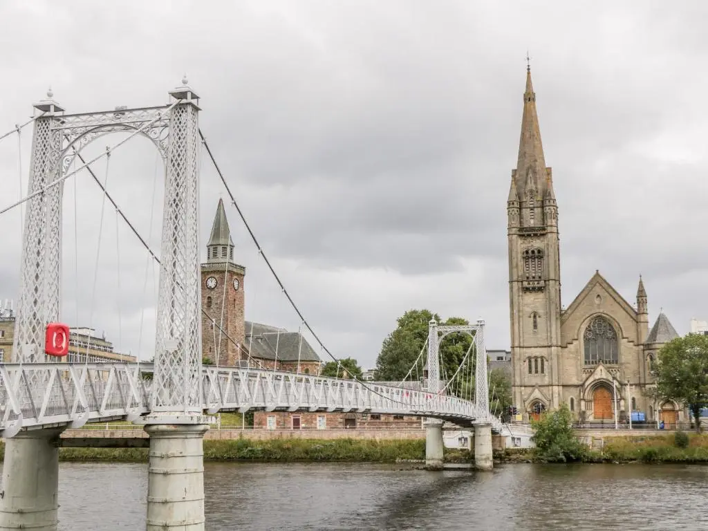 a bridge over a river in front of a cathedral at The Bell Tower in Inverness