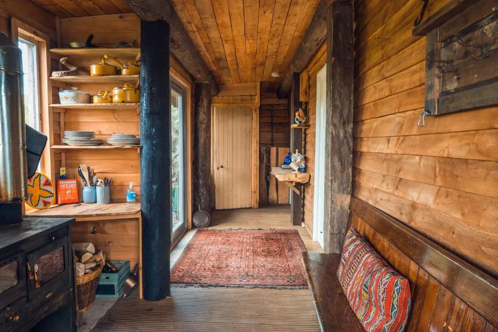 a hallway of a log cabin with a bench and a rug at Shepherd's Loch Glamping in Turriff