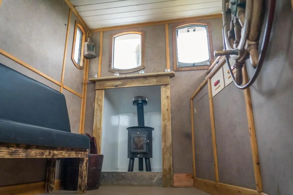 a train car with a wood stove in a room at Shepherd's Loch Glamping in Turriff